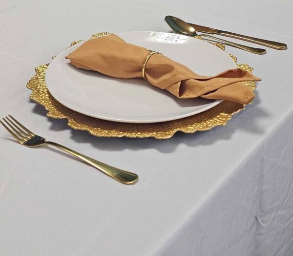 Silverware set, gold reef charger plates, gold napkin, dinner plate