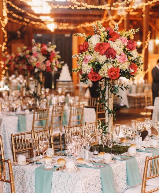 Yellow light garlands hang over the dinner tables decorated with Yellow light garlands hang over the dinner tables decorated with pink bouquets